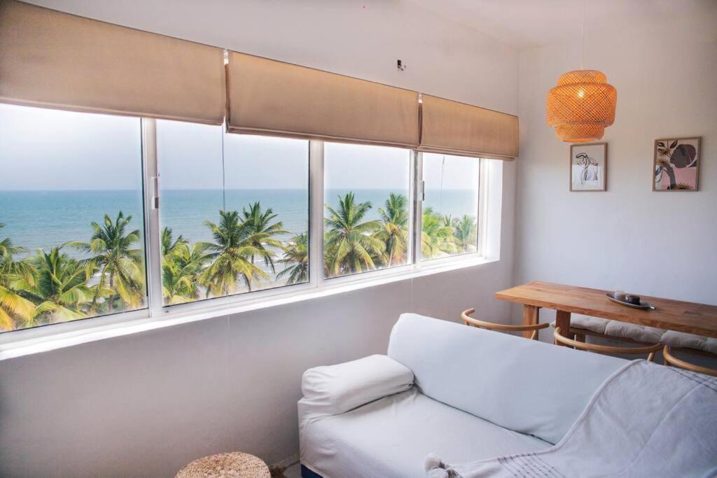 un soggiorno con divano e 2 finestre con vista sull'oceano di Casa Mare, Tucacas 