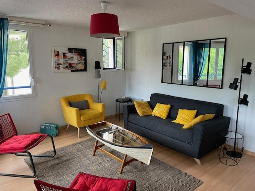 sala de estar con sofá azul y sillas amarillas en Appartement Arcachon, 3 pièces, 4 personnes - FR-1-374-161, en Arcachon