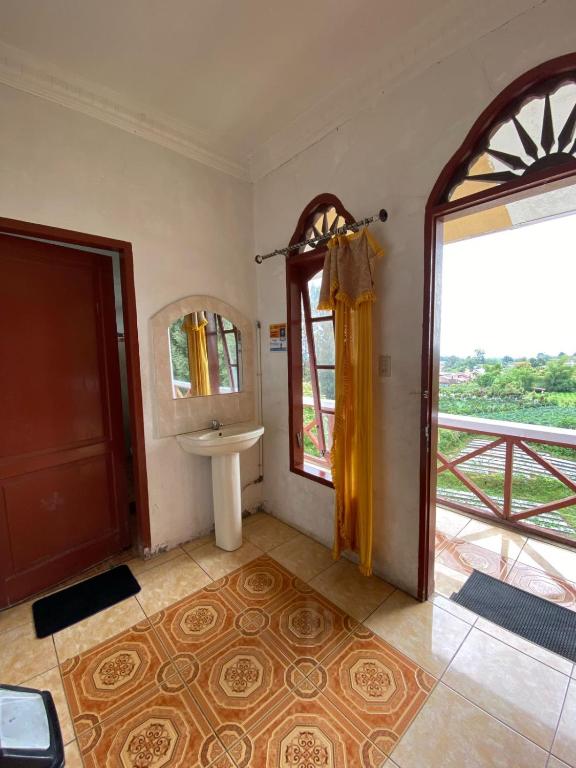 a bathroom with a sink and a window at Sibayak Multinational Rest House in Berastagi