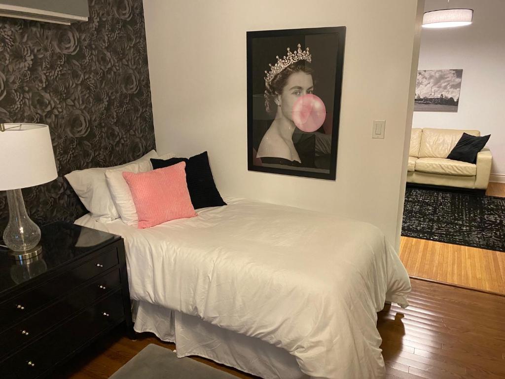 a bedroom with a bed and a portrait of a woman wearing a crown at North of Avon B&B Suites in Stratford