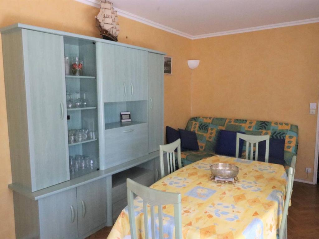 une salle à manger avec une table et une armoire dans l'établissement Appartement T2 à Royan - Plage de Pontaillac - 2 adultes/2 enfants, terrasses, parking, proche commerces - FR-1-738-32, à Royan