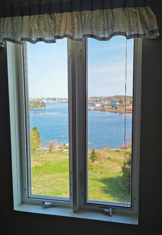 a window with a view of the water at 181 Oceanside Inn in Peggy's Cove