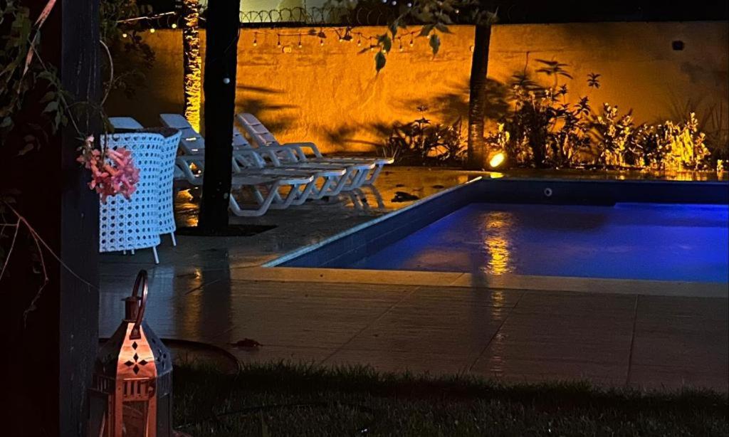a swimming pool in a backyard at night at Casa San Francisco in Porto Seguro