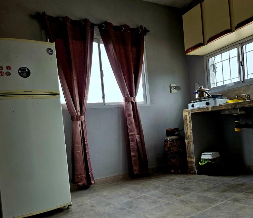 a kitchen with a refrigerator and a window at El gumer in San Fernando del Valle de Catamarca
