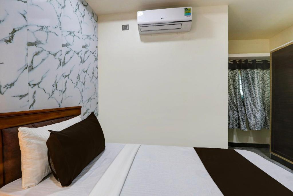 Collection O SV Delight Inn في حيدر أباد: غرفة نوم بسرير ومكيف على الحائط