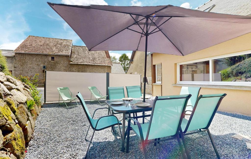 une table et des chaises avec un parasol sur une terrasse dans l'établissement Cozy Home In Sartilly-Baie-Bocage, à Angey