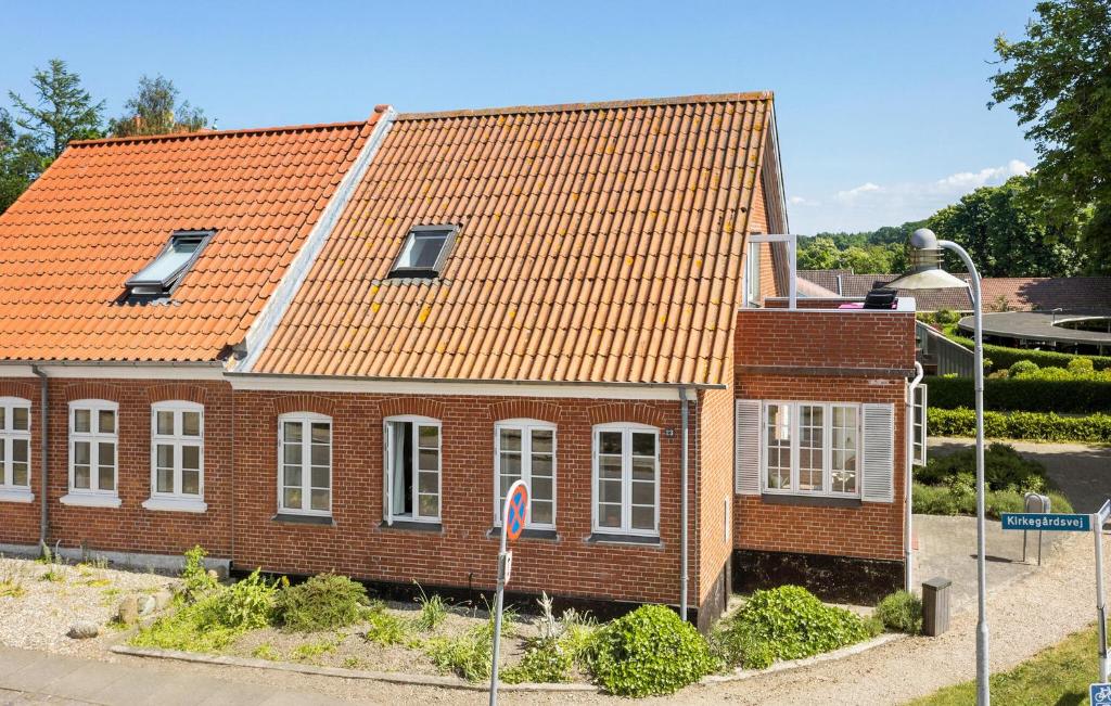 a brick house with an orange roof on a street at 2 Bedroom Beautiful Home In Rudkbing in Rudkøbing