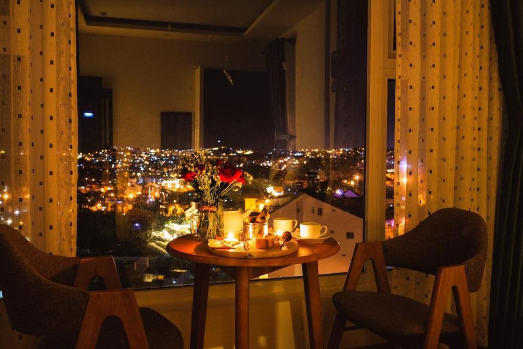 een tafel in een kamer met uitzicht op de stad bij Rose Valley Hotel Da Lat Vietnam in Da Lat