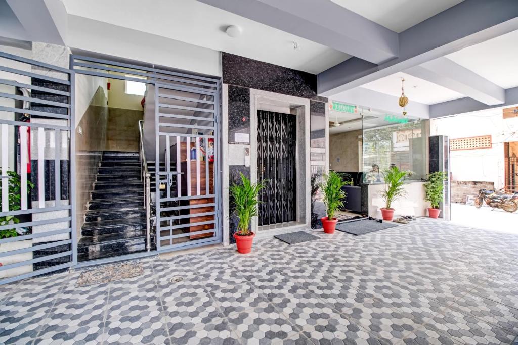 un vestíbulo con macetas y escaleras en un edificio en Collection O Hotel Vihari Grand, en Vijayawāda