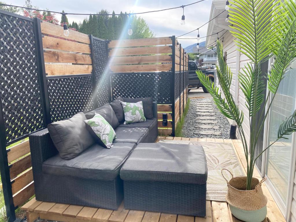 eine Couch auf einer Terrasse mit Topfpflanze in der Unterkunft A Mid Somerset Dream in West Kelowna