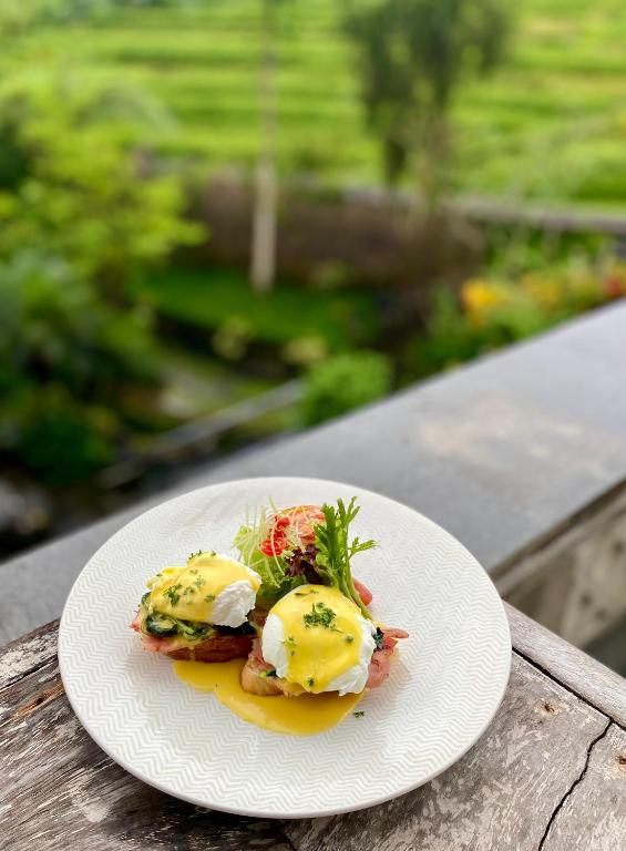 a plate of food with eggs on a table at Abian Ayu Villa in Sidemen