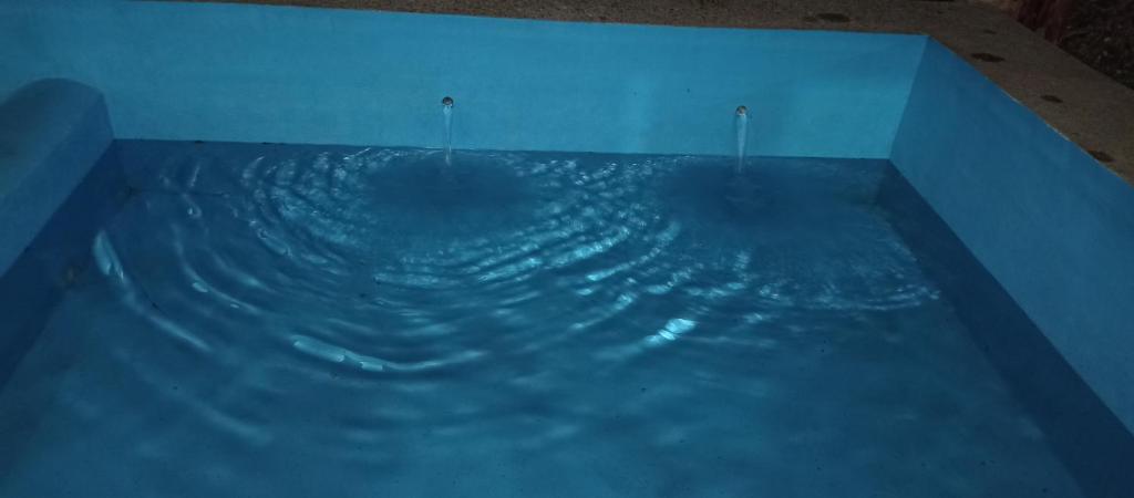 a large pool of blue water in a room at Villas Carmelita hostal in Paso de las Palmas