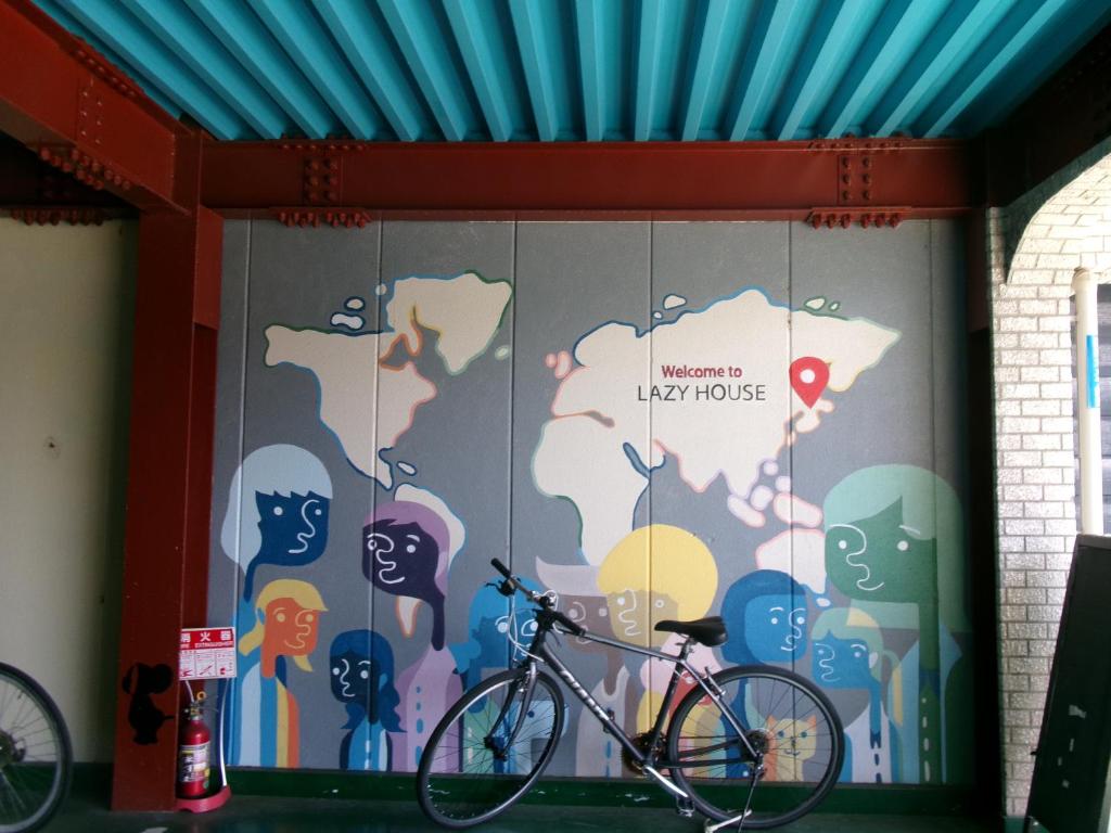 una bicicleta estacionada frente a una pared con un mural en Lazy House en Okayama