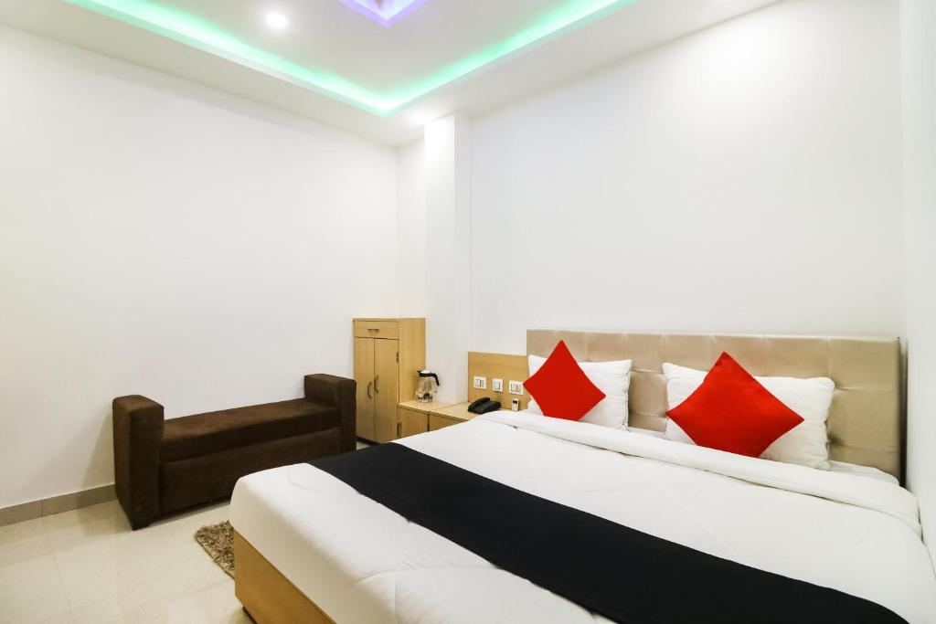 um quarto com uma cama grande e almofadas vermelhas em Capital O 61009 Hotel Raj Mahal Sarnath em Varanasi
