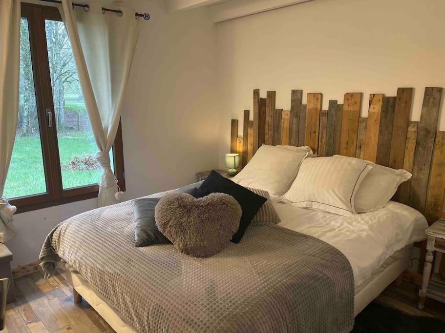 a bed with a teddy bear sitting on top of it at Gîte Les Reculons au pied du lac in Les Midoux