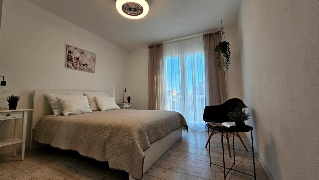 a bedroom with a bed and a window and a chair at Apartments Vahovec Vodice in Vodice
