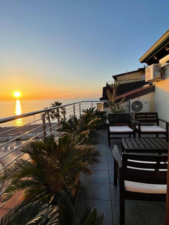 a balcony with a view of the ocean at sunset at Casa Vacanze Arya in Capo dʼOrlando