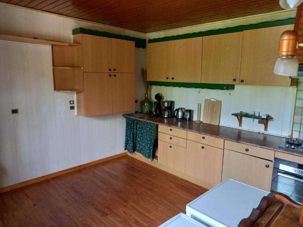 a kitchen with wooden cabinets and a wooden floor at Bellavie2 in La Bresse