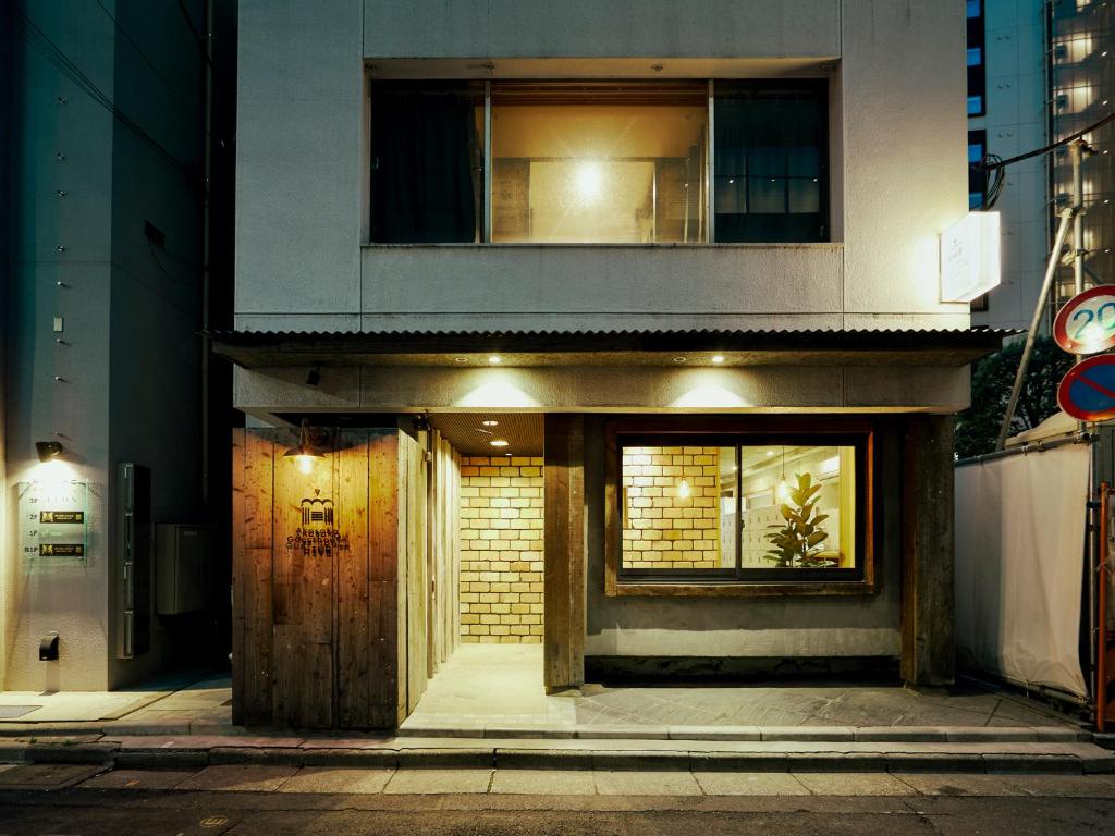 ein Gebäude mit einer Holztür und einem Fenster in der Unterkunft Akasaka Guesthouse HIVE in Tokio