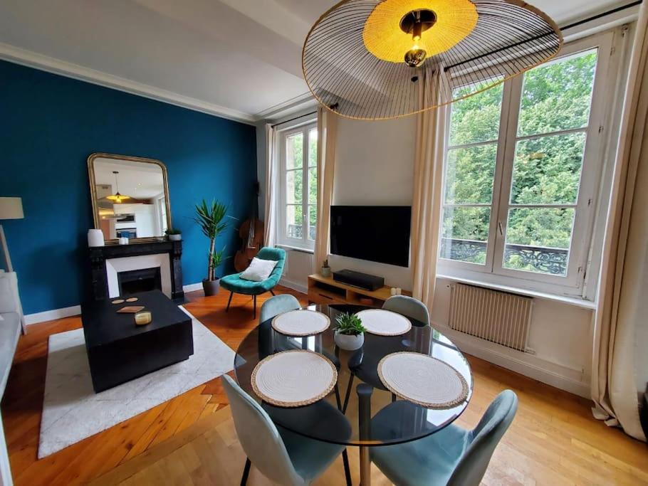 un salon avec une table, des chaises et une télévision dans l'établissement Le Repère - T2 Haut de Gamme Rouen Centre, à Rouen