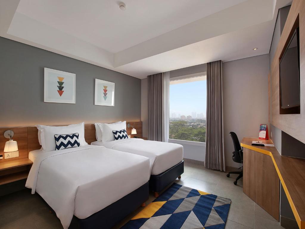Postel nebo postele na pokoji v ubytování Swiss-Belinn Simatupang