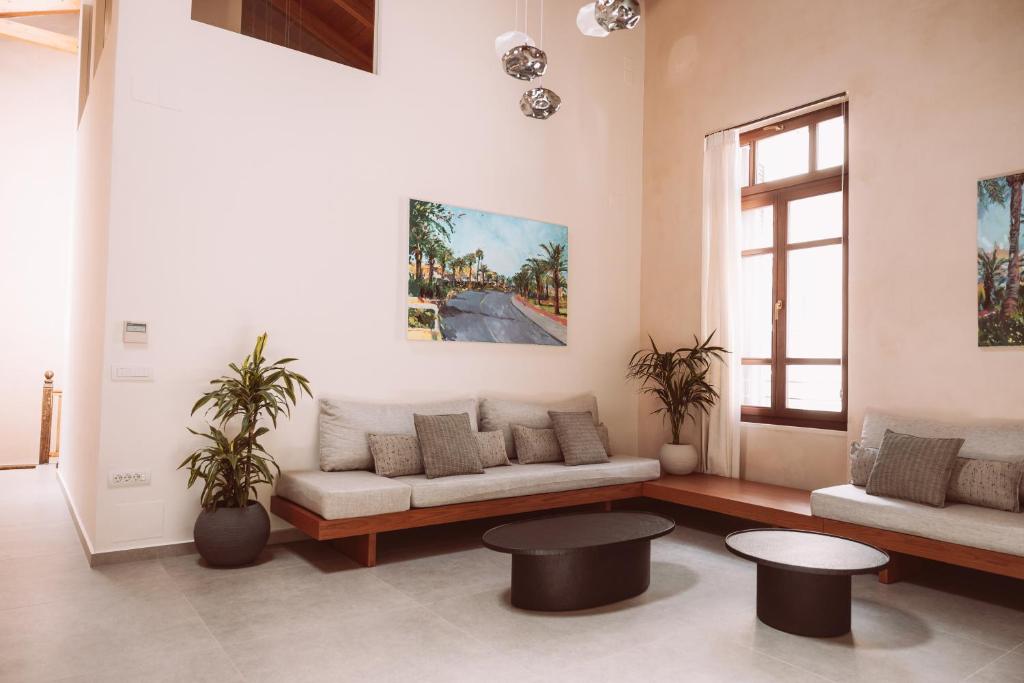 uma sala de estar com um sofá e duas mesas em MAZI - Pied à Terre em Rethymno Town