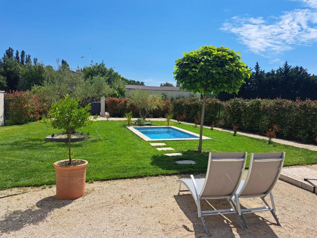 une cour avec deux chaises et une piscine dans l'établissement Maison en campagne, à Avignon