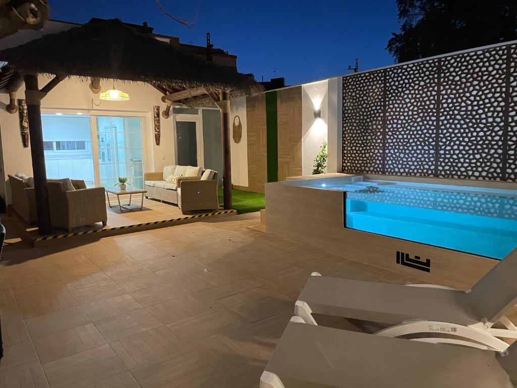 a patio with a swimming pool and some chairs at WonderStays Villa Lucía in Málaga