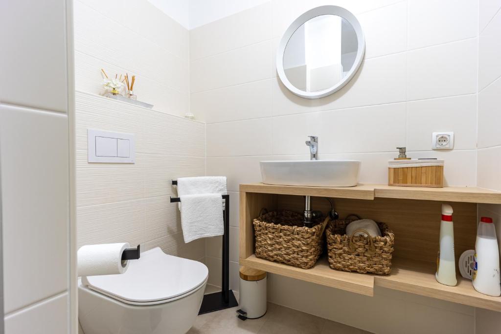 W łazience znajduje się toaleta, umywalka i lustro. w obiekcie Apartments Sea Rabac w Rabacu