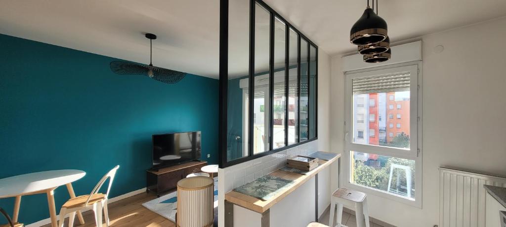 a living room with blue walls and a table and chairs at Cozy apartment at Paris doors with free car-park in Saint-Denis