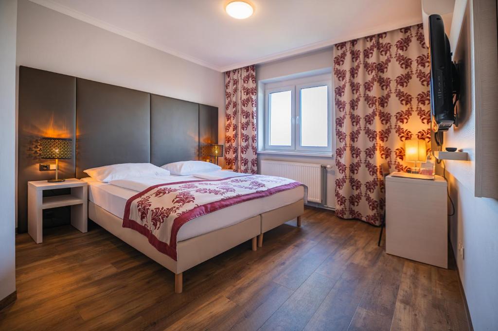 a bedroom with a large bed and a television at Arion Airport Hotel in Schwechat