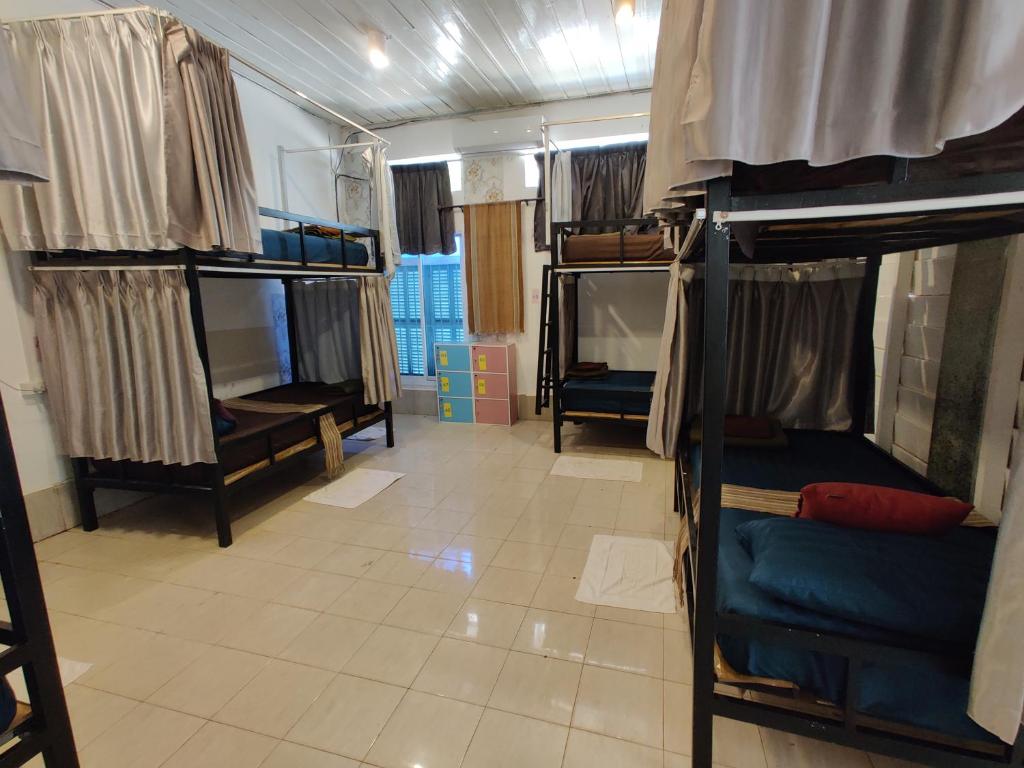 Pokój z 3 łóżkami piętrowymi i podłogą wyłożoną kafelkami w obiekcie Via Hostel Pakse w mieście Pakxé