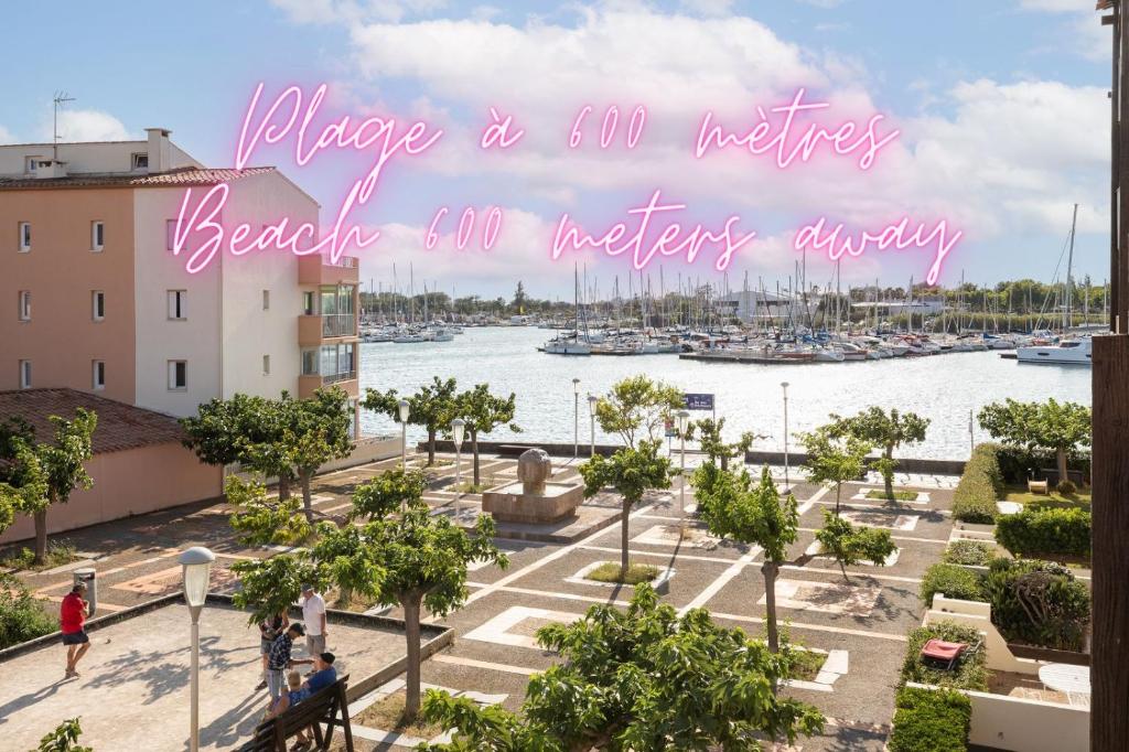 une vue d'une marina avec un panneau rose indiquant s'il vous plaît un million d'hectares dans l'établissement Escapade sur l'Île des Pêcheurs, au Cap d'Agde