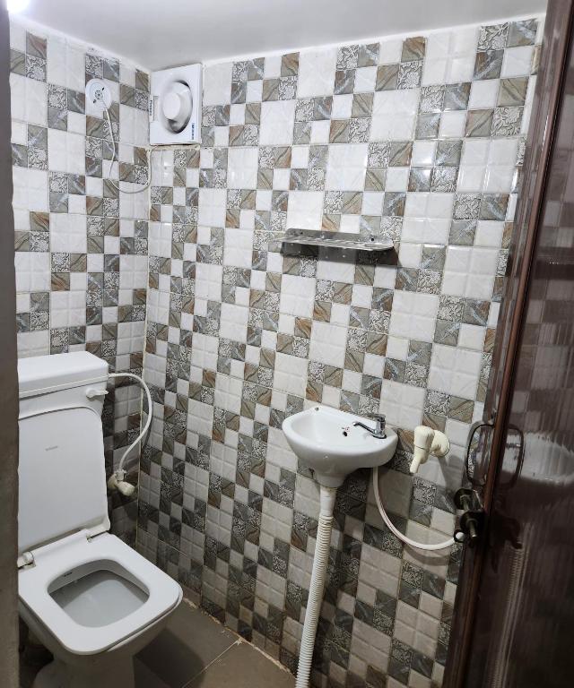 La salle de bains est pourvue de toilettes et d'un lavabo. dans l'établissement Mauji's Villa Hotel & Guest House, à Prayagraj