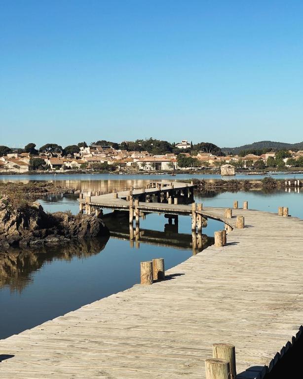 un quai en bois sur une masse d'eau dans l'établissement Appartement 1 chambre, à Peyriac-de-Mer