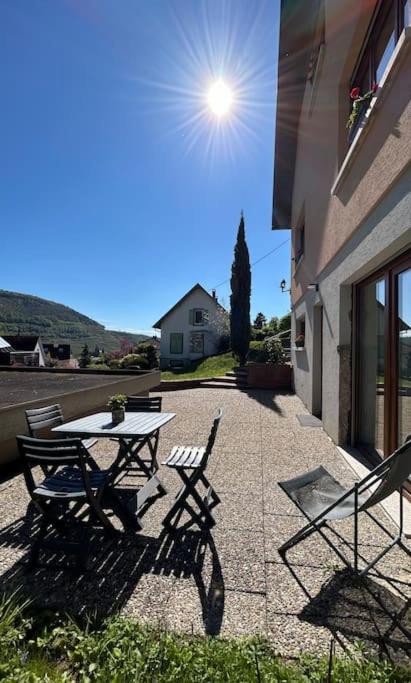 une table et des chaises assises sur un trottoir à côté d'un bâtiment dans l'établissement Appartement Chez Maria, à Guebwiller