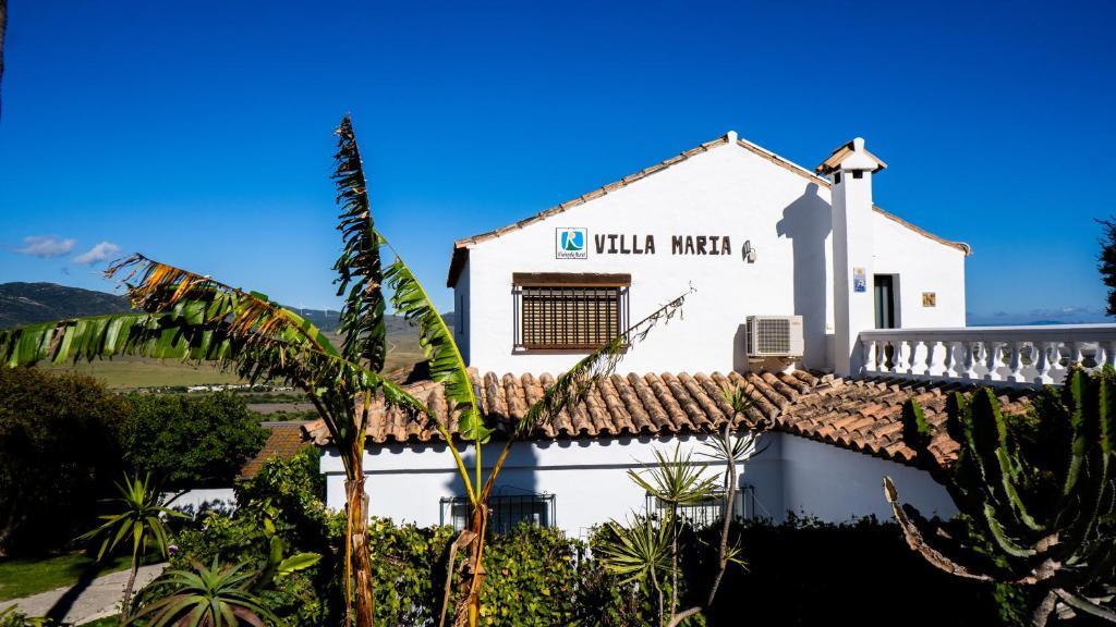 un edificio blanco con un cartel. en Rural Tarifa Villa María, en Tarifa