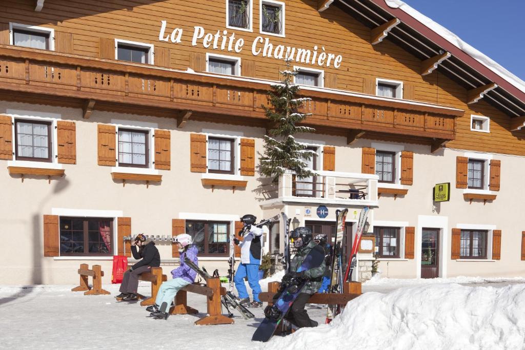 eine Gruppe von Personen auf Skiern vor einem Gebäude in der Unterkunft Logis Hôtel La Petite Chaumière in Gex