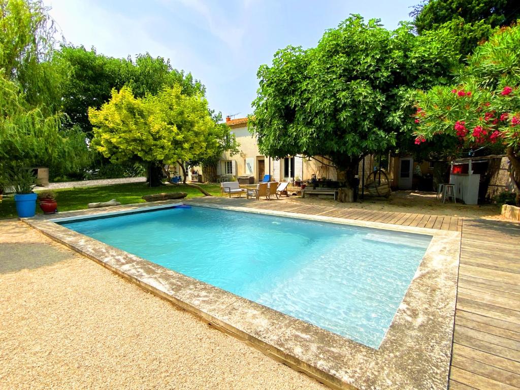 une piscine avec de l'eau bleue dans une cour dans l'établissement Grande maison, 5 chambres, piscine à 5 min d'Arles, à Fourques