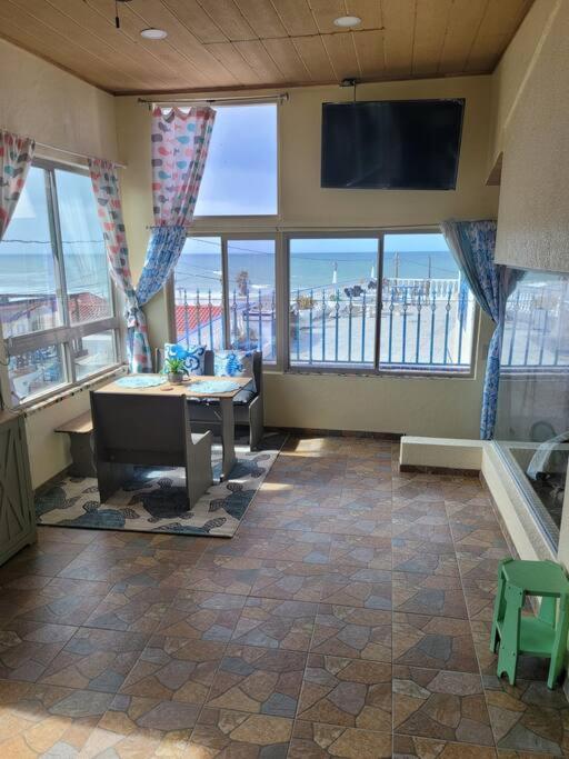a room with a table and a tv and windows at Casa Grace en Playa Del Sol-15 in San Antonio del Mar