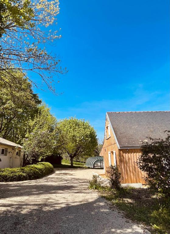 une grange avec une allée à côté d'un bâtiment dans l'établissement Maison Papillon, à Turenne
