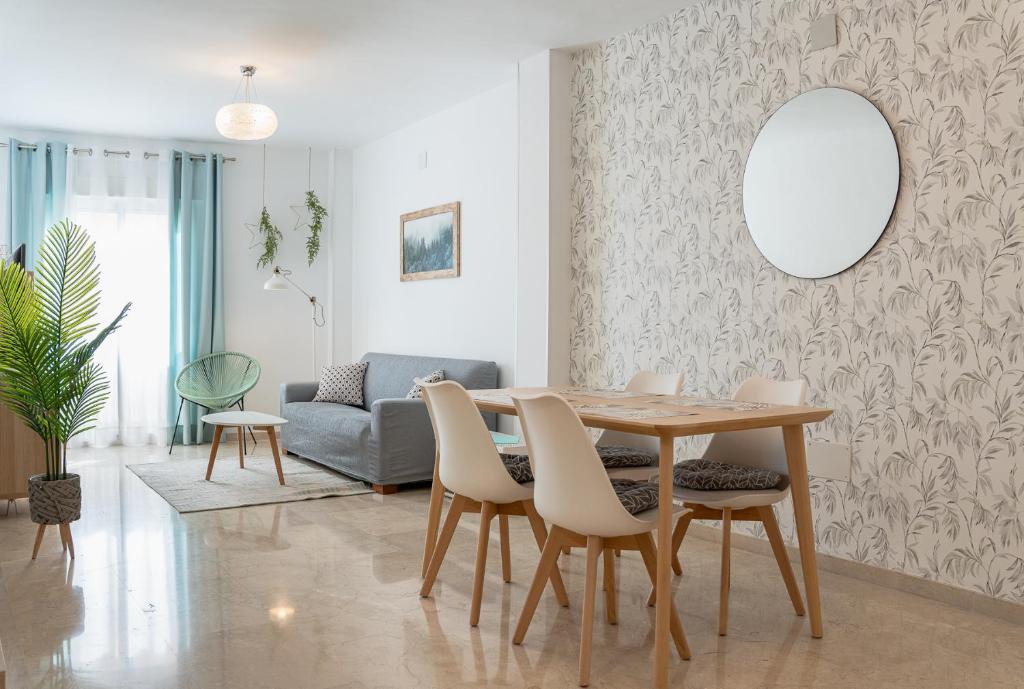 ein Wohnzimmer mit einem Tisch, Stühlen und einem Sofa in der Unterkunft Apartamento Biznaga in Alhaurín de la Torre