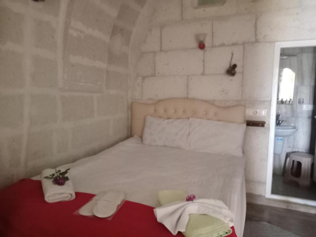 - une chambre avec un lit et des serviettes dans l'établissement ULAŞ CAVE HOTEL, à Ürgüp