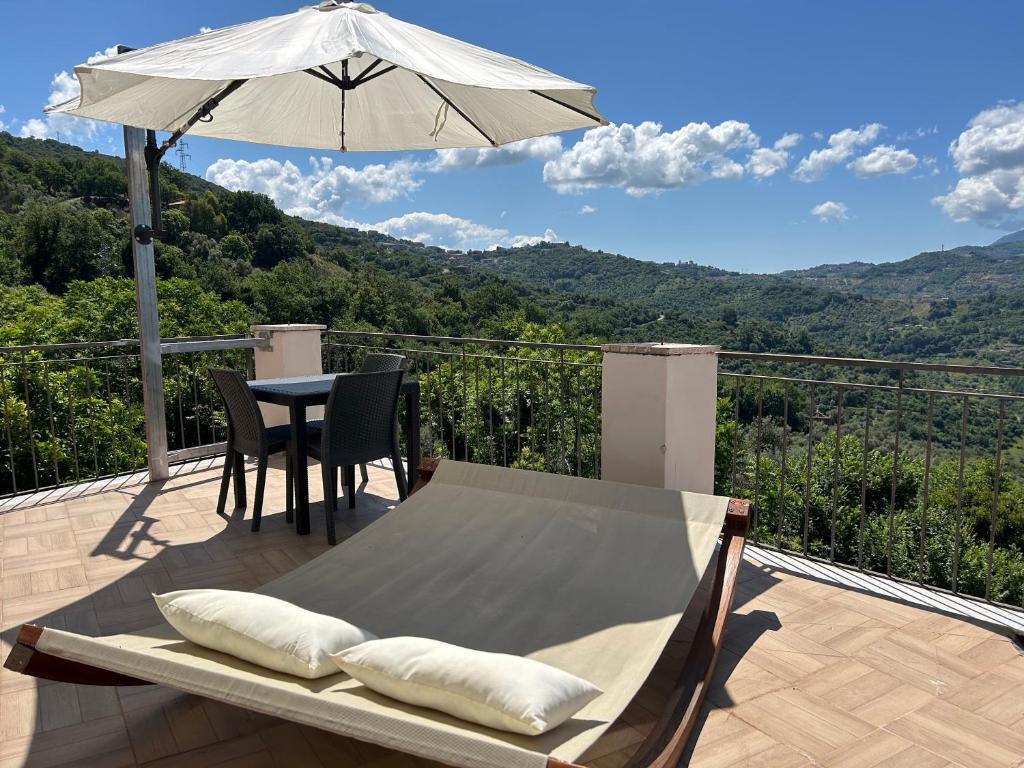 une terrasse avec un parasol, une table et des chaises dans l'établissement Ca’del Borgo B&B Country House, à Ogliastro Cilento