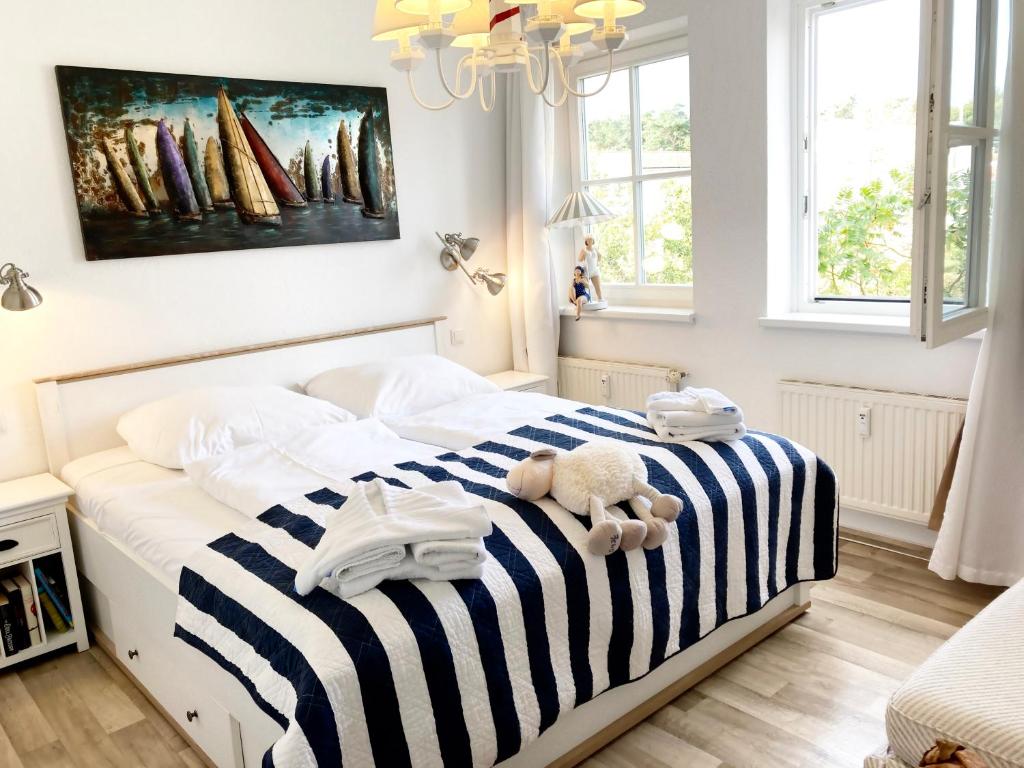 キュールングスボルンにあるFewo Strandstraße - führt auf die schöne Ostsee-Seebrückeのベッドルーム1室(青と白のストライプの毛布付きのベッド1台付)