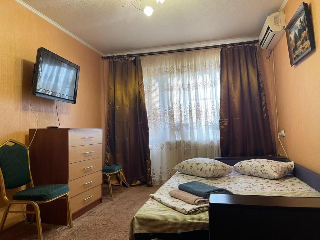 ein kleines Schlafzimmer mit einem Bett und einem Fenster in der Unterkunft Гагарина ДАФФИ in Dnipro