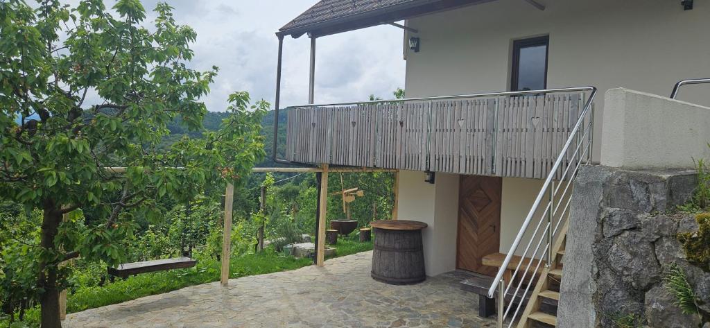 ein Haus mit einem Balkon und einem Baum in der Unterkunft Zidanica Muhič in Dolenjske Toplice