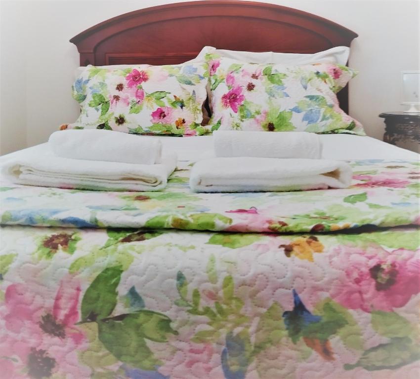 1 cama con edredón y almohadas de flores en Julia House Holidays Nazaré, en Nazaré