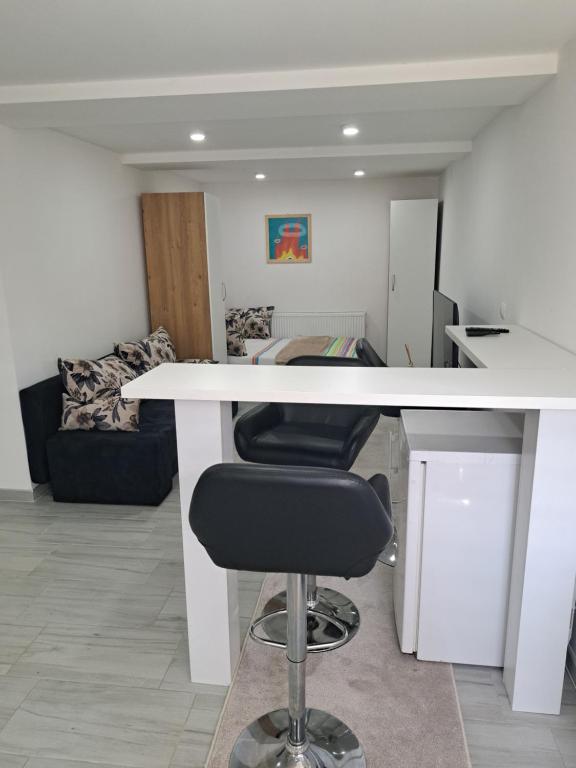 an office with a white table and a black chair at Apartman Avlija in Tuzla