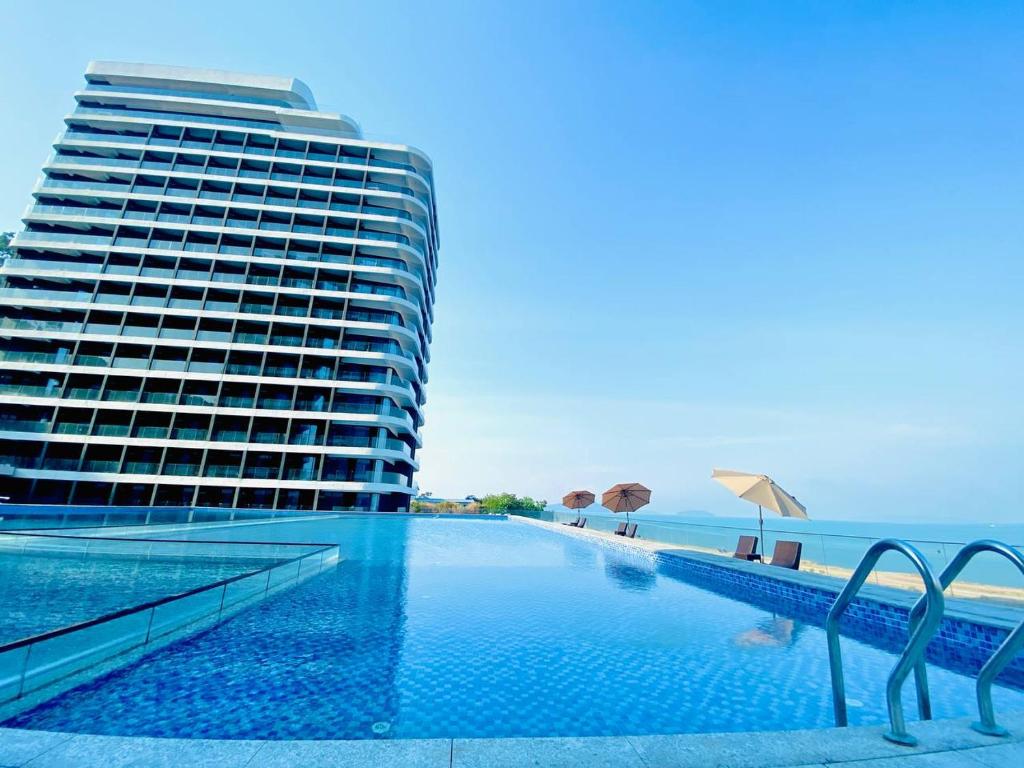 uma piscina de hotel ao lado de um grande edifício em Ark Seaview Holiday Inn em Sihanoukville